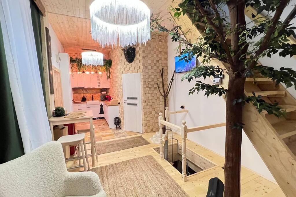 a living room with a staircase and a tree at The Stable House in Bucharest