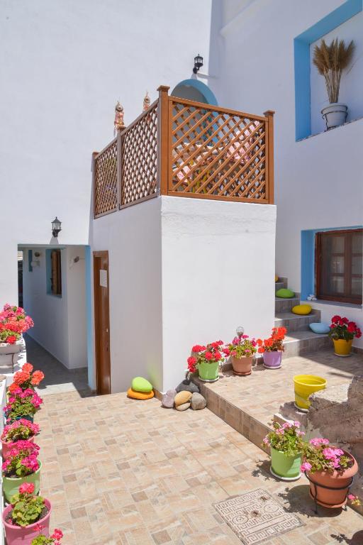 a patio with potted plants and flowers inront of a building at nikola's house in Adamantas