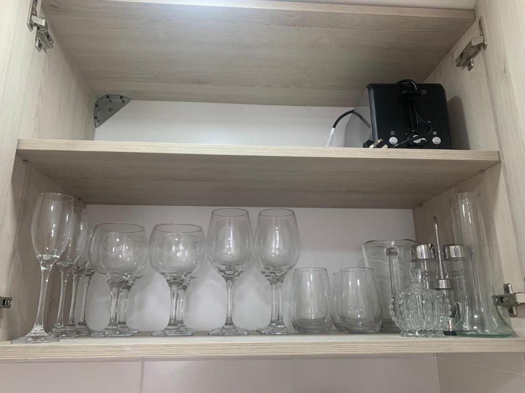 une rangée de verres à vin assis sur une étagère dans l'établissement AIKA Monoambientes, à Salta