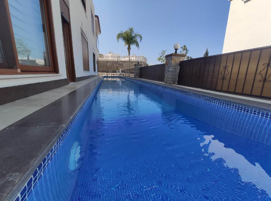 a blue swimming pool next to a building at Denizolgun Homes Eska Villa 1+1 in Dalaman