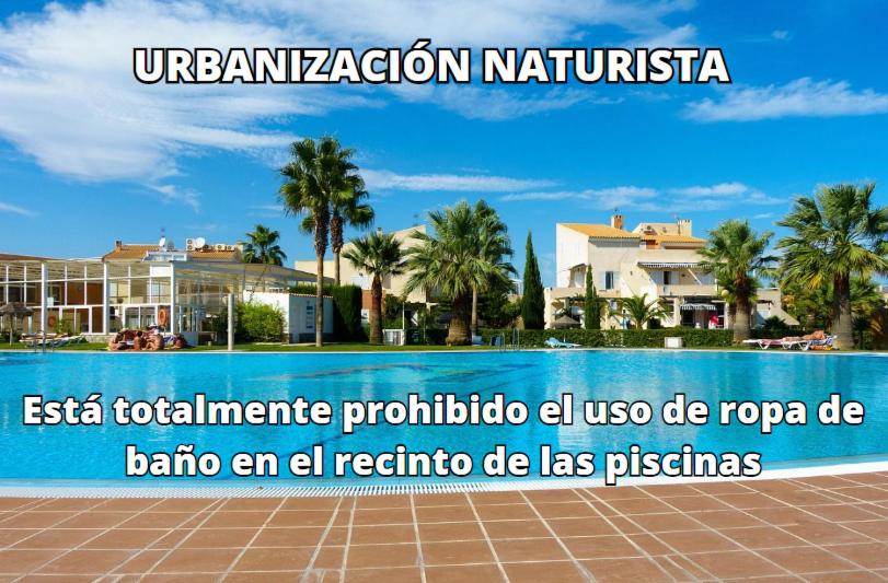 un cartel frente a una piscina con palmeras en Vera Natura Apartamento Isabel, en Vera