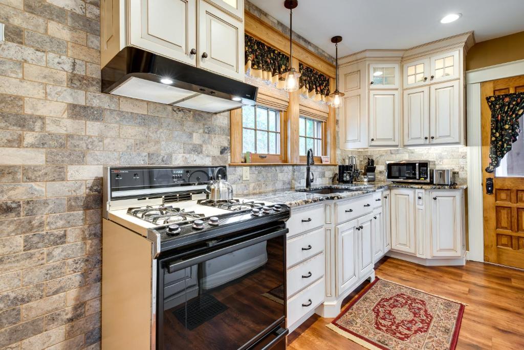Una cocina con gabinetes blancos y un horno de estufa. en Pennsylvania Abode Near Little League World Series, en Williamsport
