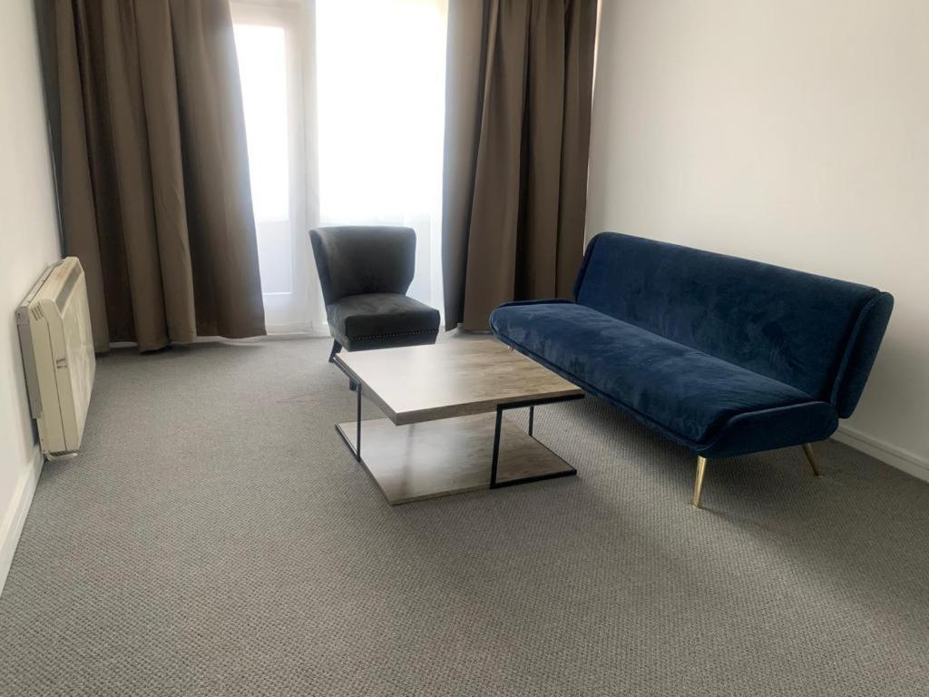 um sofá azul e uma cadeira num quarto em Beautiful-2 bedroom Apartment, 1 bathroom, sleeps 6, in greater london (South Croydon). Provides accommodation with WiFi, 3 minutes Walk from Purley Oak Station and 10mins drive to East Croydon Station em Purley