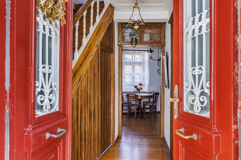 un couloir avec des portes rouges et une salle à manger dans l'établissement House Vasaki, à Skopelos