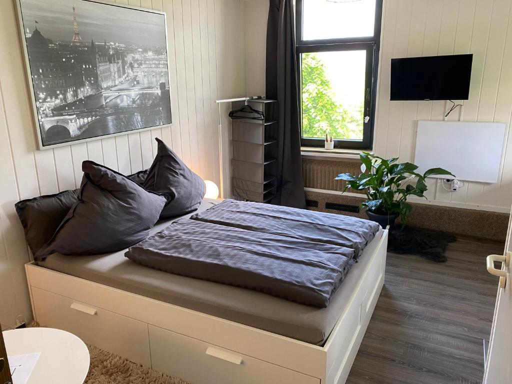um quarto com uma cama num quarto com uma televisão em Cosy Studio in Kempen em Kempen