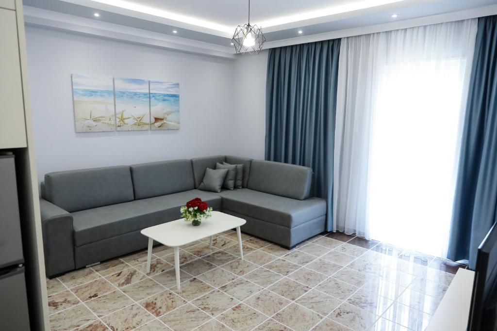 a living room with a couch and a table at Fishta apartments Q5 35 in Velipojë