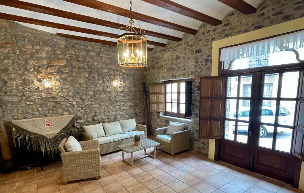 salon z kanapą i kamienną ścianą w obiekcie Casa Tío Romana Somhome w mieście Santa Magdalena de Pulpis