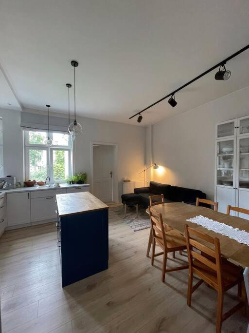 a kitchen and a living room with a table and chairs at Przestronne mieszkanie w kamienicy in Gdańsk