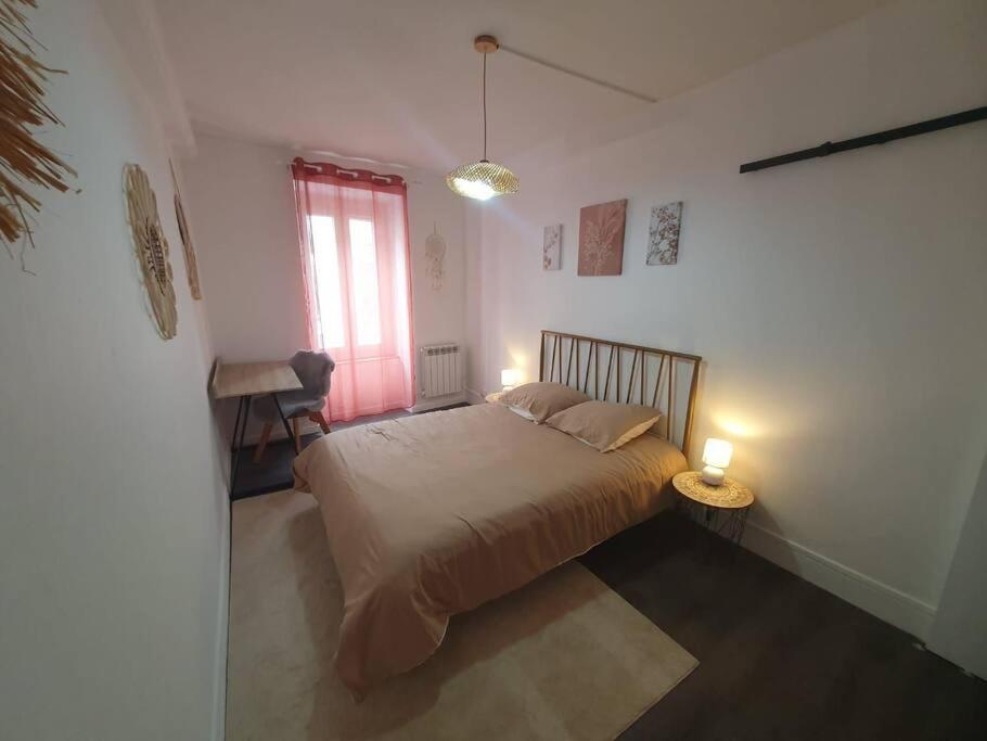 une chambre avec un lit, une table et une fenêtre dans l'établissement Cocon Cosy, à Clermont-Ferrand
