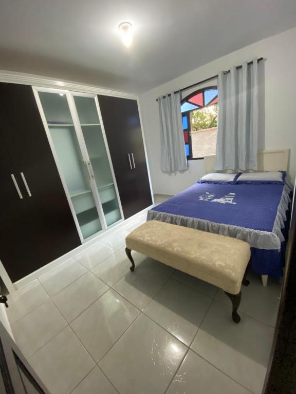 a bedroom with a bed and a bench in it at Casa em Santa Teresa-ES in Santa Teresa