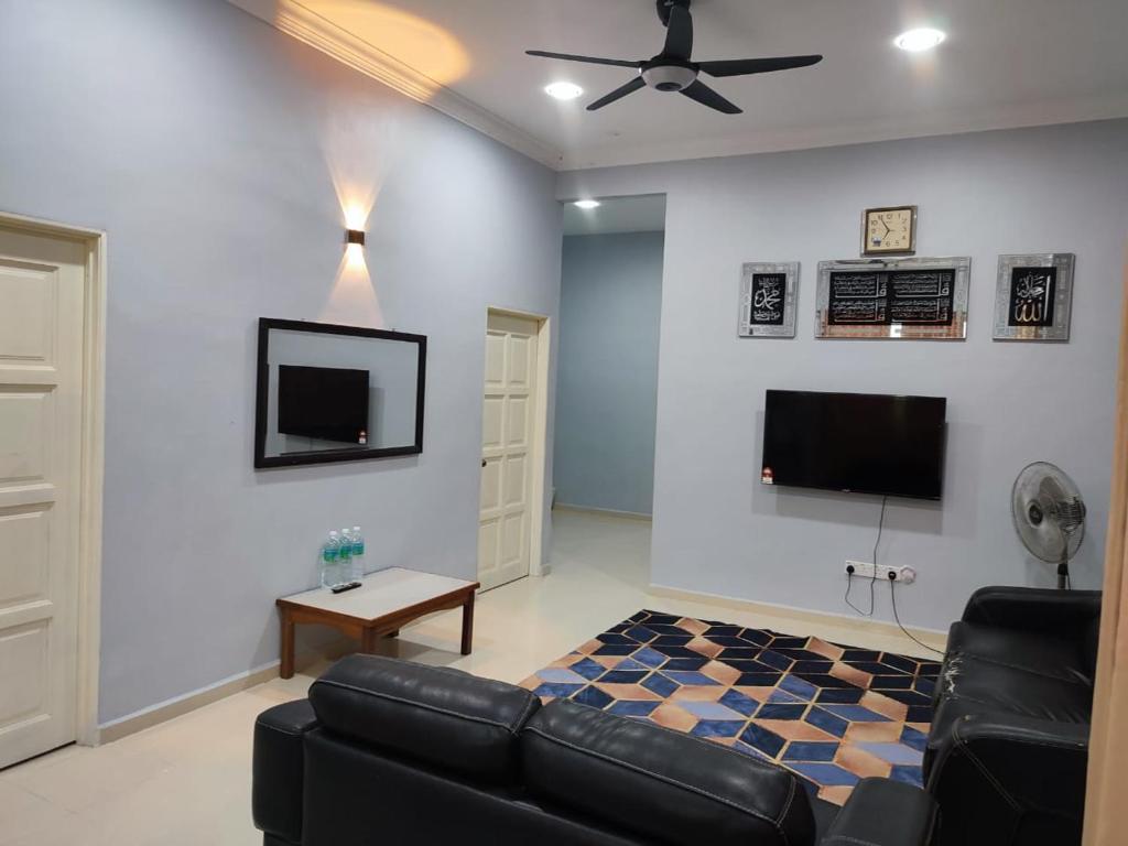 ein Wohnzimmer mit einem Sofa und einem Flachbild-TV in der Unterkunft Bella Homestay Perlis in Arau