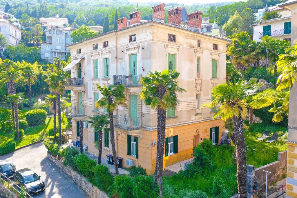 an apartment building in a city with palm trees at Apartment with patio 50m from the beach and Lungomare in Opatija