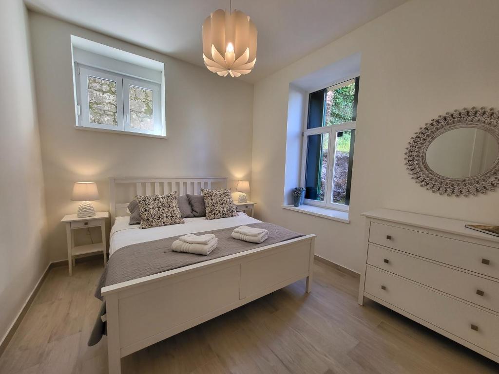 sypialnia z łóżkiem, komodą i lustrem w obiekcie Apartment with patio 50m from the beach and Lungomare w mieście Opatija