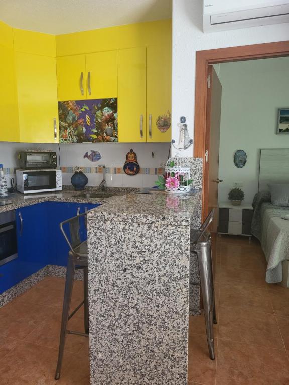 uma cozinha com armários amarelos e uma bancada em Apartamento La Urba em Roquetas de Mar