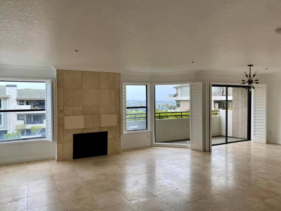 uma ampla sala de estar com lareira e janelas em Ocean View Newport Beach GEM! Ideal Longer Stays em Newport Beach