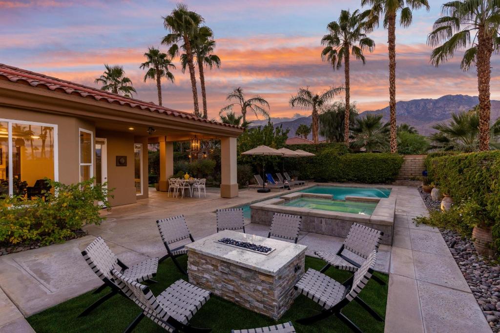 een patio met een tafel en stoelen en een zwembad bij Mon Cheri Estate in Palm Springs