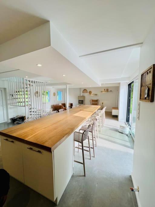 une grande cuisine avec un long bar avec tabourets dans l'établissement Les volets bleus, à Saint-Venant