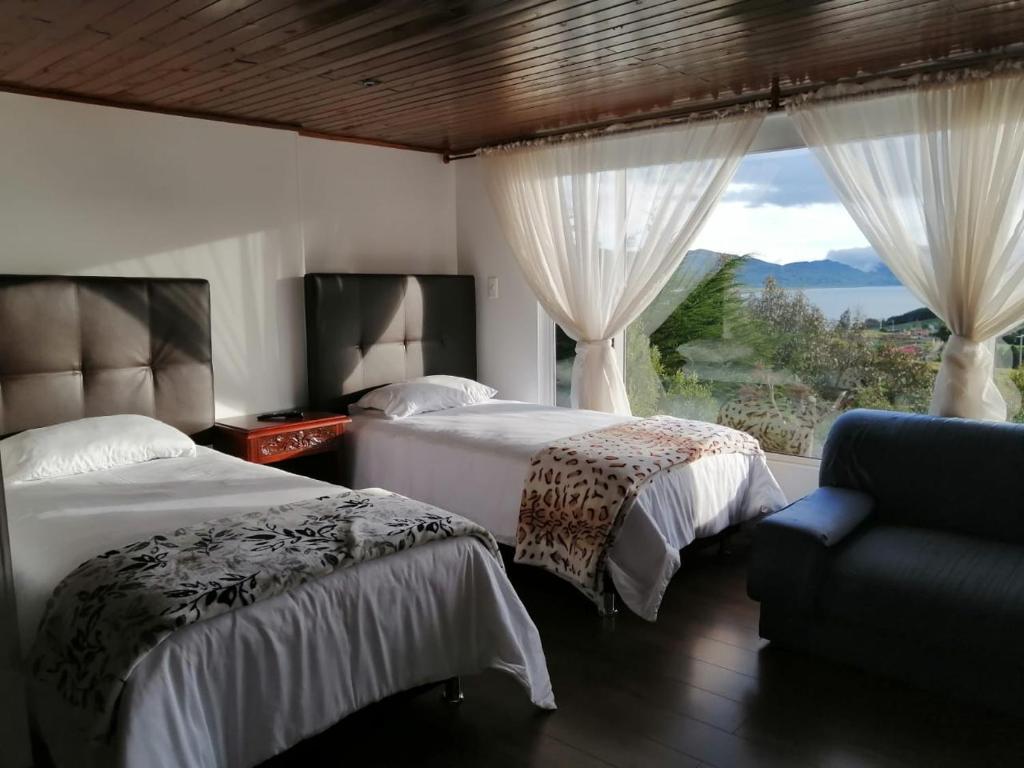 1 dormitorio con 2 camas, sofá y ventana en Chalet_Laguna_Azul, en Aquitania