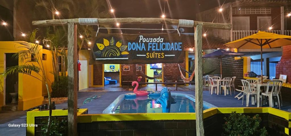 a small swimming pool in a restaurant at night at Pousada Dona Felicidade Suítes in Tamandaré