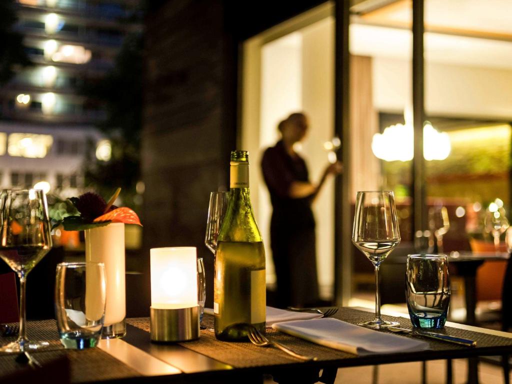 a table with a bottle of wine and wine glasses at Novotel Amsterdam City in Amsterdam