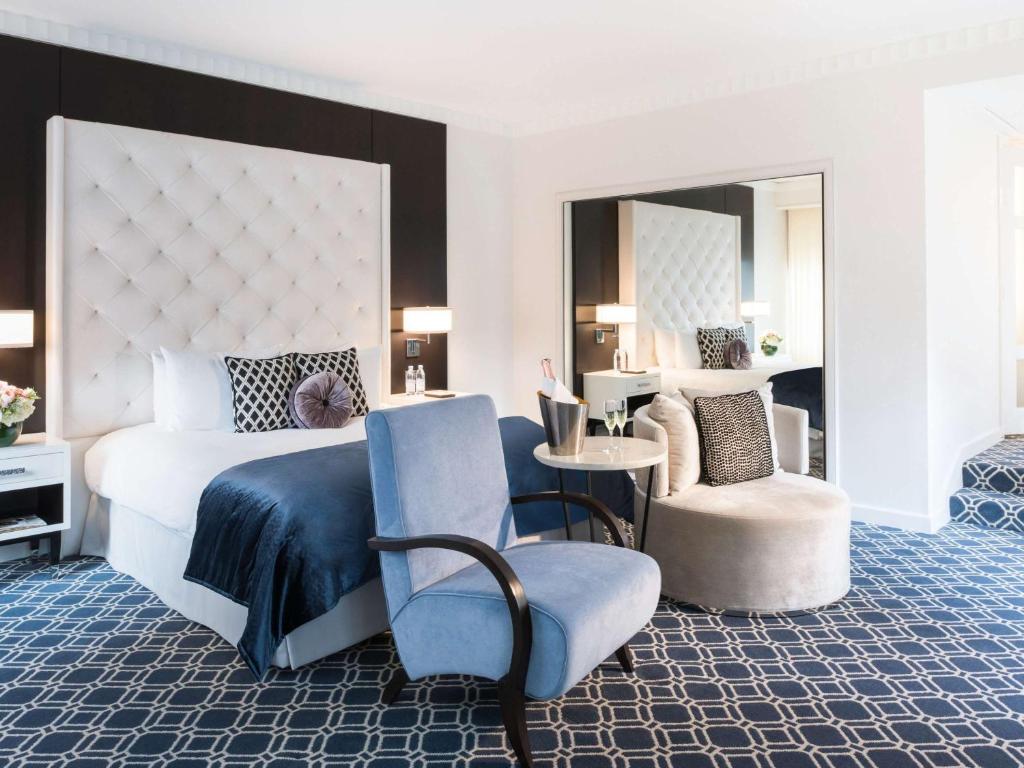 a bedroom with a king sized bed and a chair at Sofitel Lafayette Square Washington DC in Washington