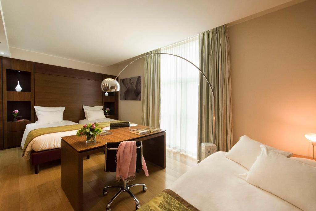 a hotel room with two beds and a desk at Best Western Premier BHR Treviso Hotel in Quinto di Treviso