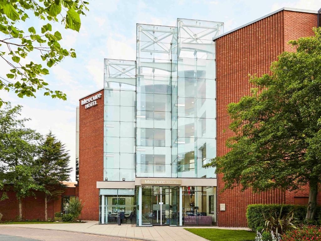 un bâtiment en briques avec une façade en verre dans l'établissement Mercure St Helens, à St Helens