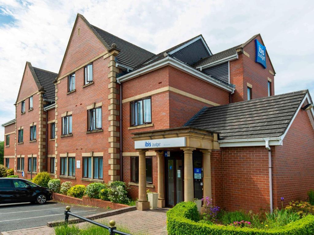a large red brick building with a black roof at Ibis Budget Bromsgrove in Bromsgrove