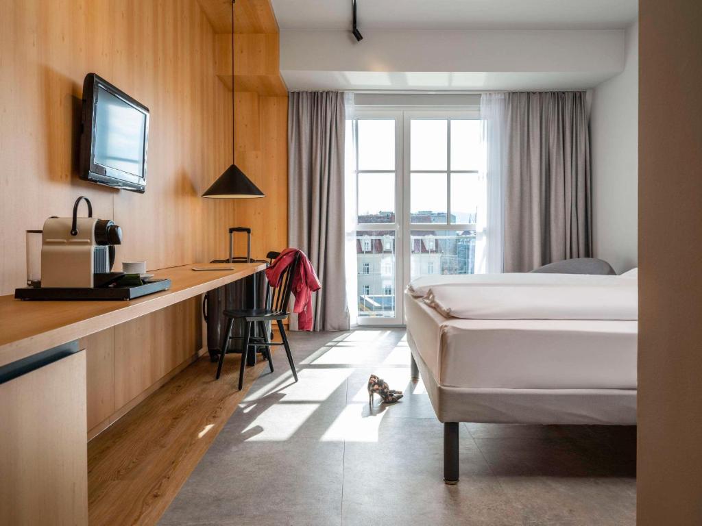 ein Hotelzimmer mit einem Bett und einem Schreibtisch in der Unterkunft ibis Styles Graz Messe in Graz