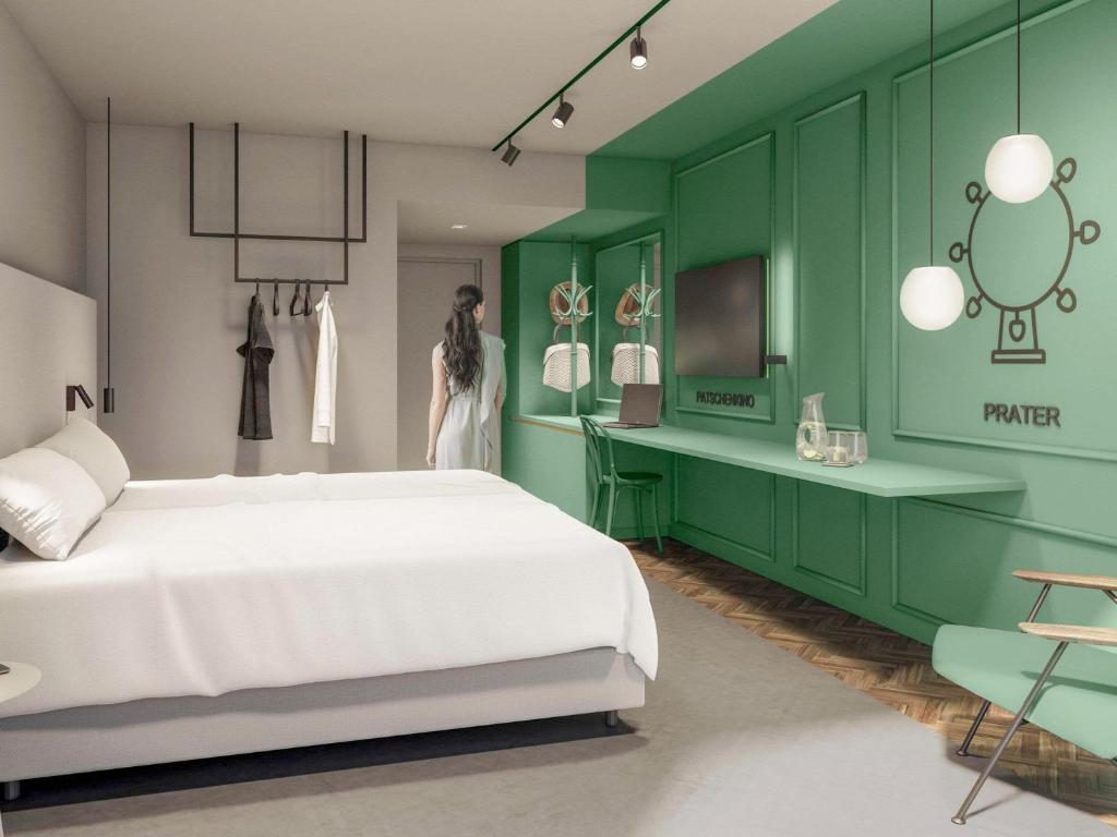 um quarto com uma cama branca e uma parede verde em ibis Styles Graz Messe em Graz