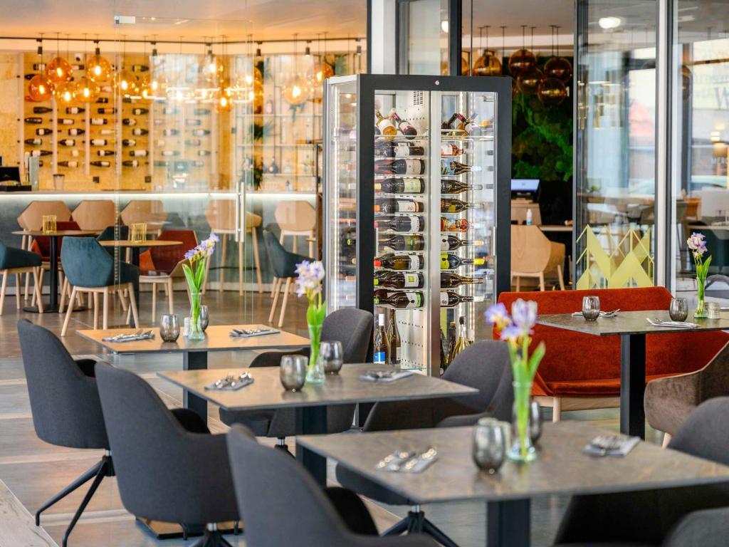 un restaurante con mesas, sillas y estantes para vinos en Mercure Tokaj Center, en Tokaj