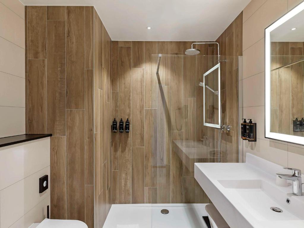 a bathroom with a shower and a white sink at Mercure Namur Hotel in Namur