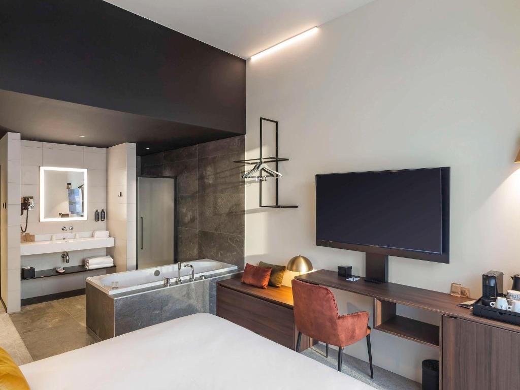 a hotel room with a bed and a television at Mercure Namur Hotel in Namur