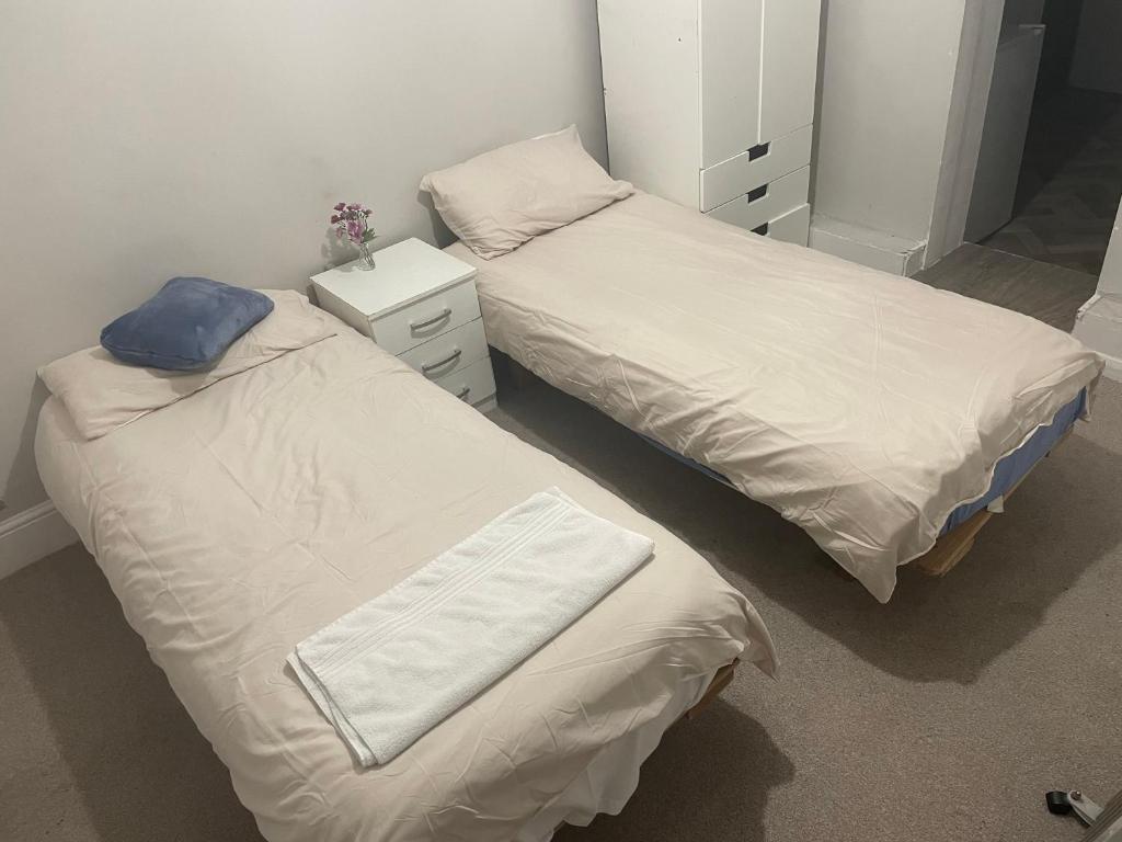 dos camas sentadas una al lado de la otra en un dormitorio en Edgware Rooms en Stone Grove