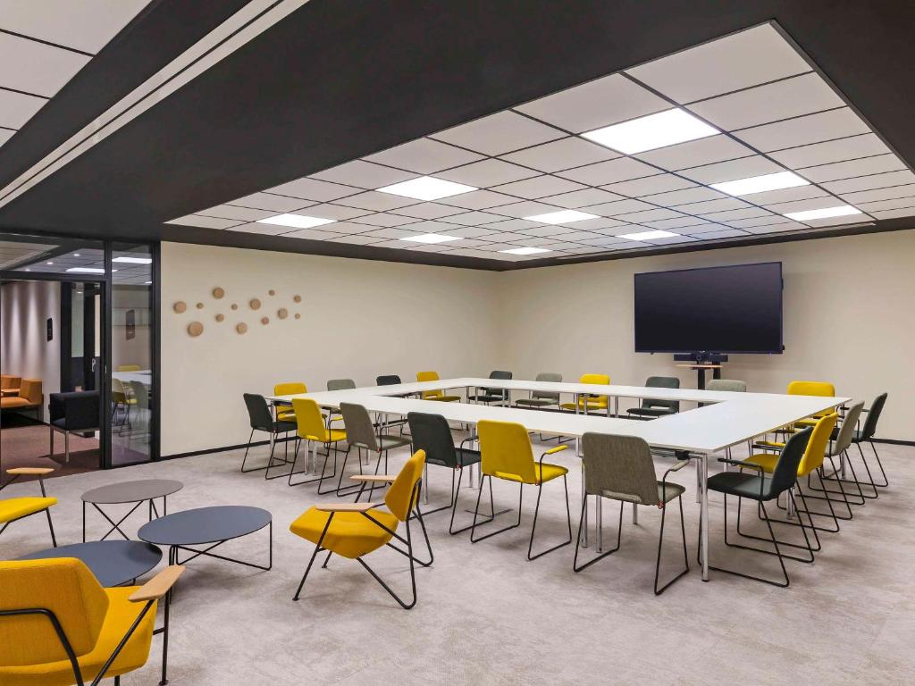 a conference room with a large table and chairs at Mercure Namur Hotel in Namur