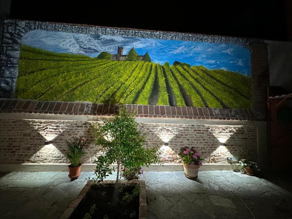 um mural de uma vinha numa parede com vasos de plantas em Residenza Nikol em Casale Monferrato