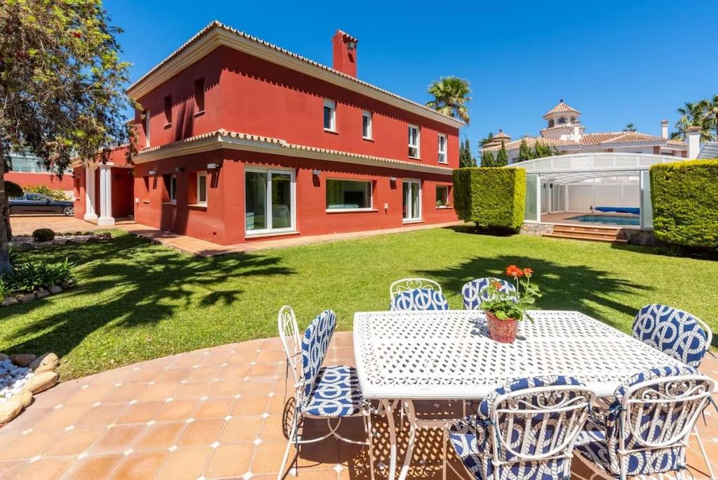 - une table et des chaises dans la cour d'une maison dans l'établissement Ohana Luxury Villa with Heated Pool, à Malaga