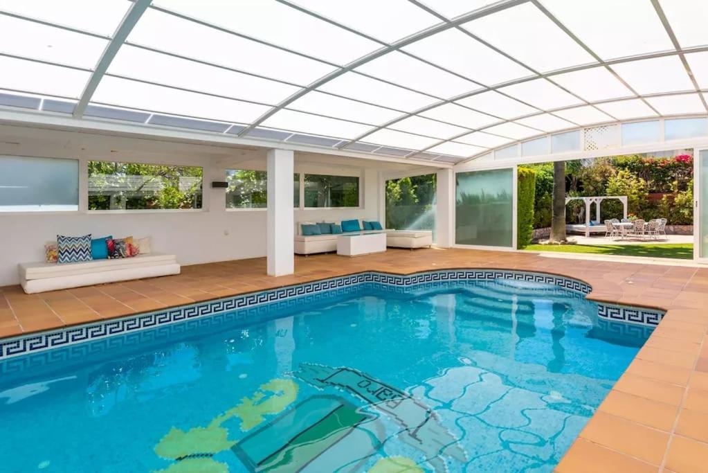 an indoor swimming pool with a large ceiling at Ohana Luxury Villa with Heated Pool in Málaga