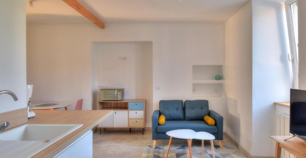 ein Wohnzimmer mit einem blauen Stuhl in der Küche in der Unterkunft Bleu Azur - Trégor in Ploubezre