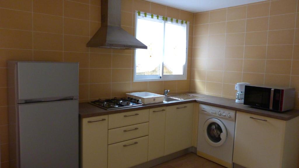 a kitchen with a refrigerator and a washer and dryer at In Tavignanu in Sortipiani