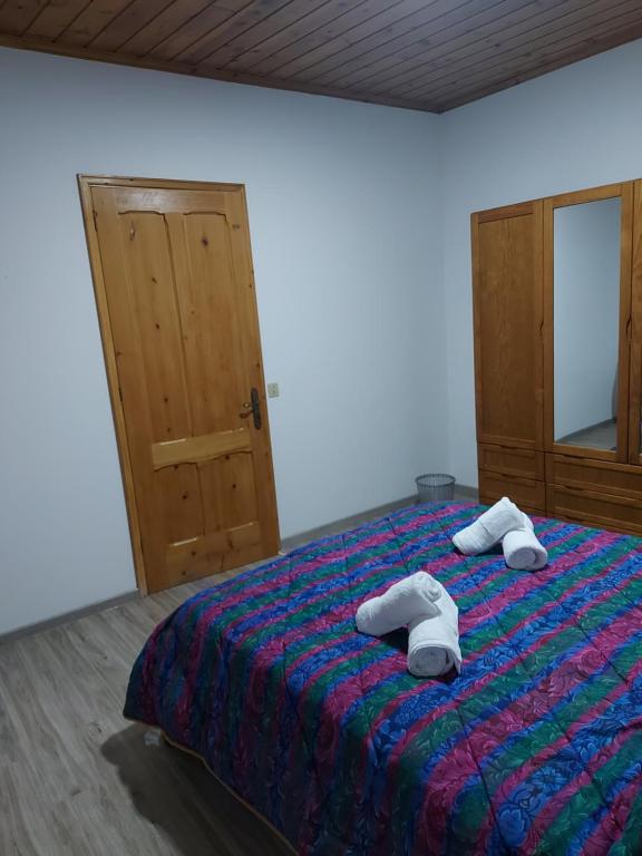 a bedroom with a bed with two towels on it at Casas da Tia Florinda - Casa Flor de Laranjeira in Faial da Terra