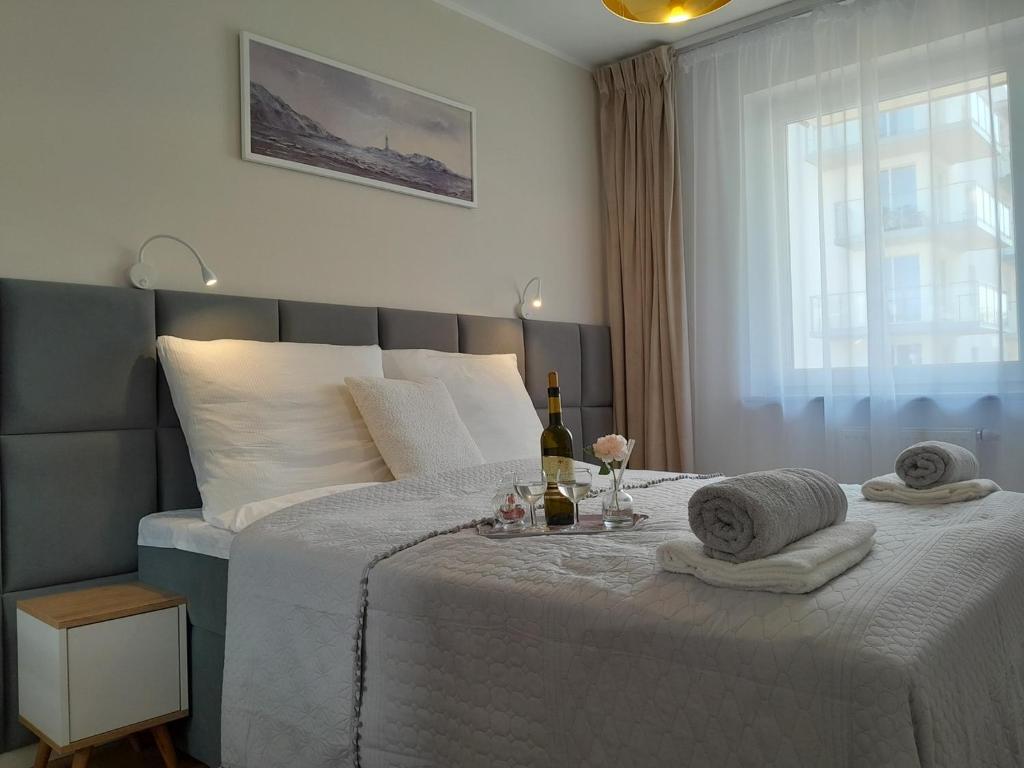 a bedroom with a large white bed with towels on it at Arte Porta Mare in Kołobrzeg