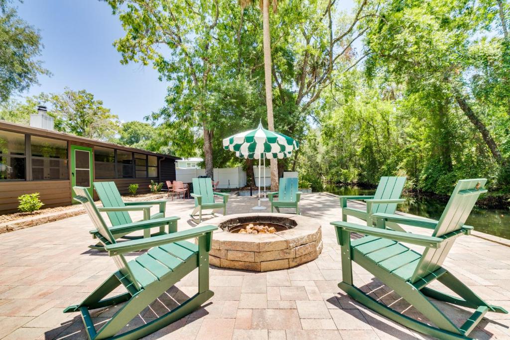 un grupo de sillas verdes sentadas alrededor de una hoguera en Riverfront Cottage in Homosassa Chateau Relaxo, en Homosassa