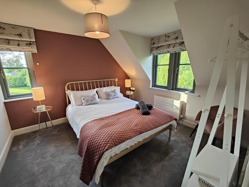 a bedroom with a bed and two windows at Chic Classy & Cosy in Lough Erne 5* Resort in Ballycassidy