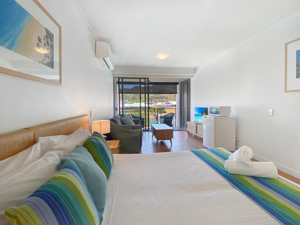 a bedroom with a bed and a living room at Blue on Blue Studio Room 1222 in Nelly Bay