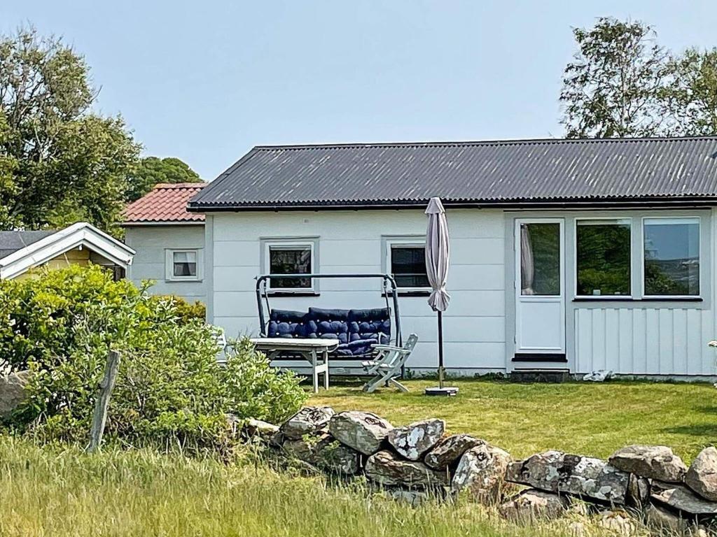 a chair and an umbrella in front of a house at 4 person holiday home in FALKENBERG in Falkenberg