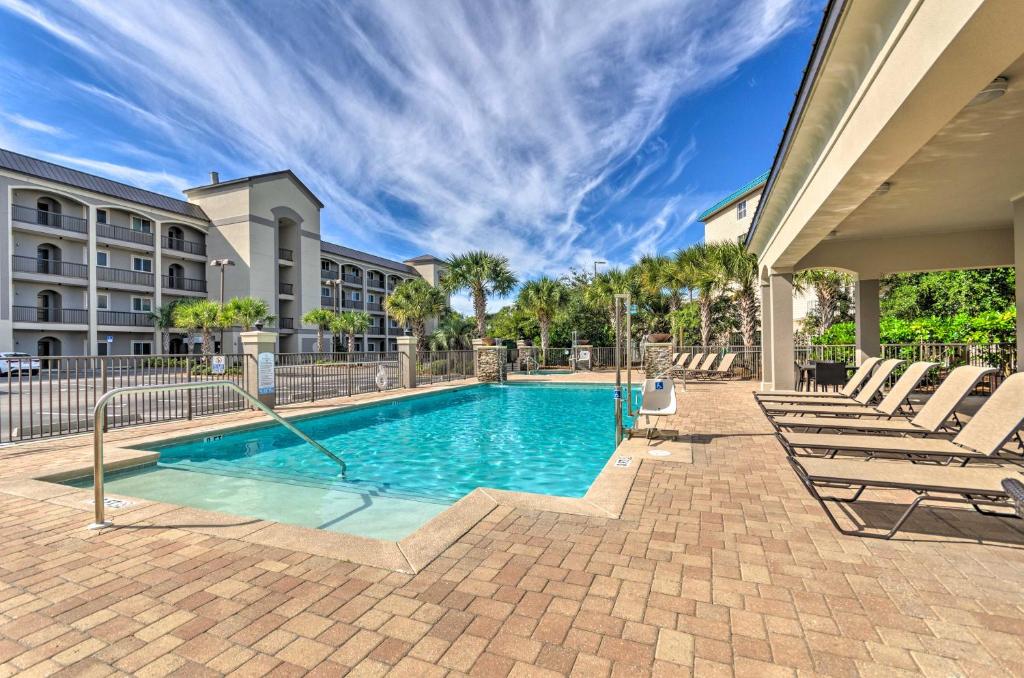 uma piscina com espreguiçadeiras e um edifício em Miramar Beach Condo with Pool - Walk to Beach! em Destin