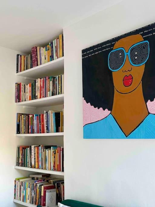 una pintura de una mujer con gafas en un estante de libros en Home in Chiswick Homefields, en Londres