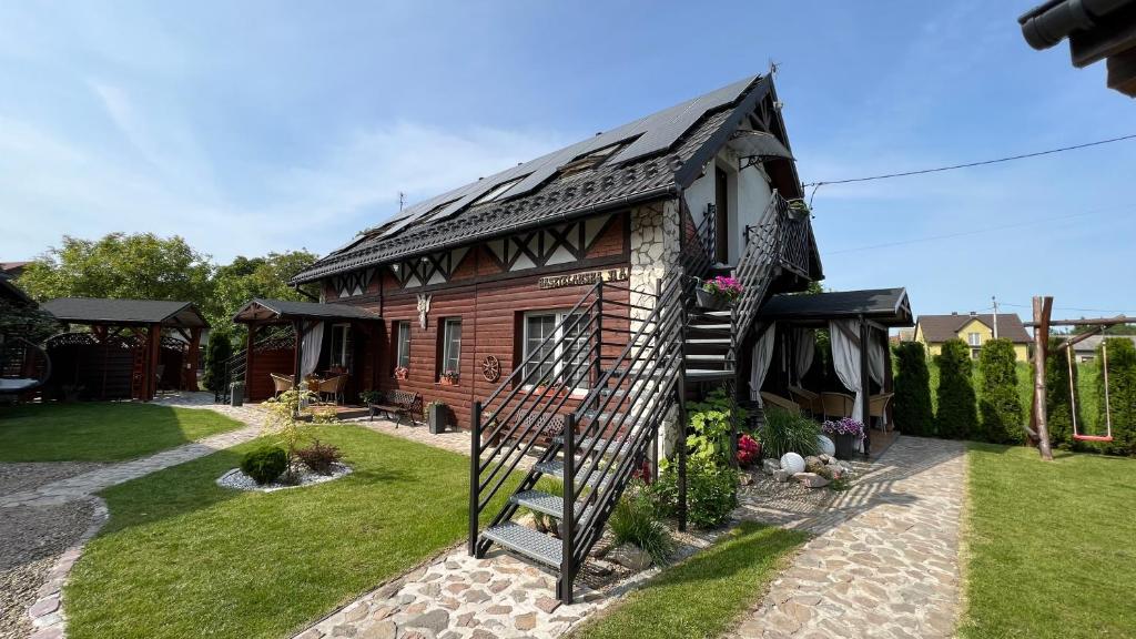 una casa de madera con una escalera de caracol en un patio en Country House - apartamenty blisko Energylandii en Spytkowice
