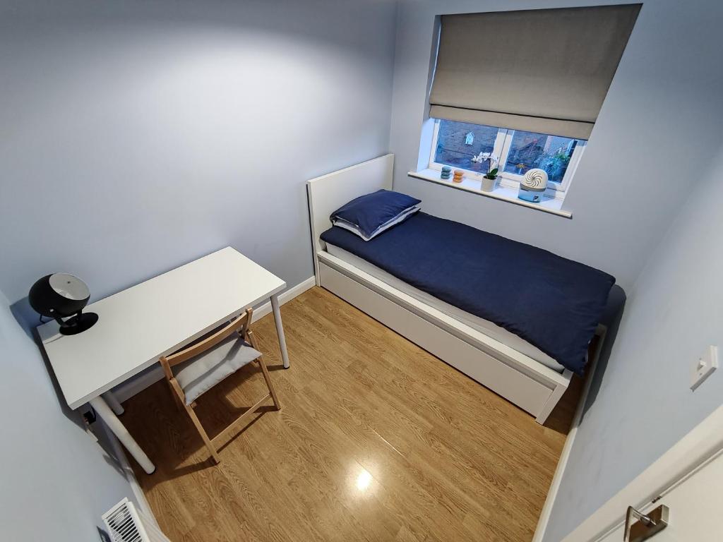 a small bedroom with a small bed and a window at Joshua Court Single Room in Stoke on Trent